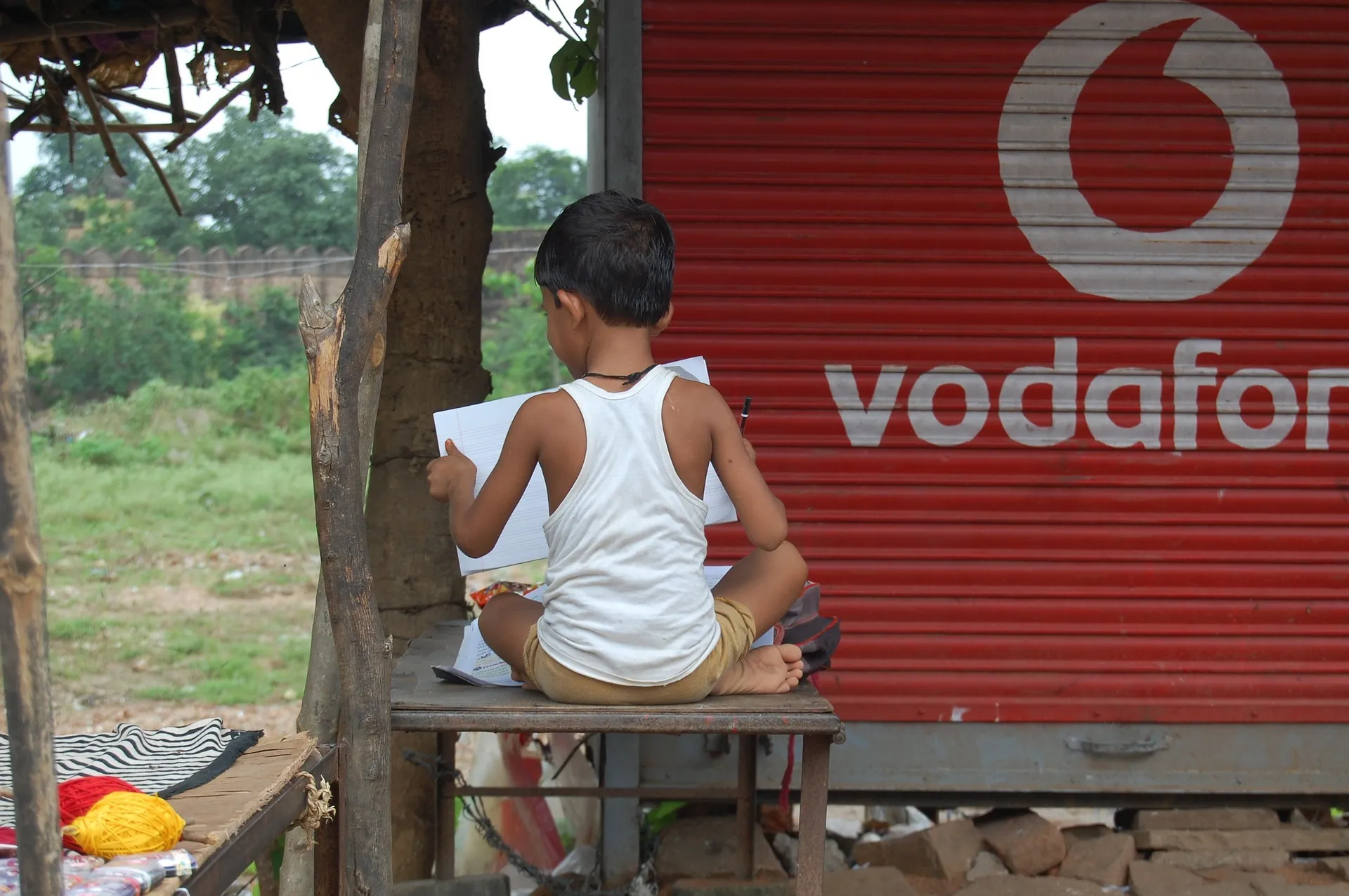 Indischer Junge vor Vodafone Signet